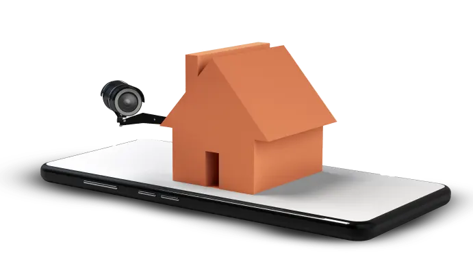 A small model house lying on top of a cell phone with a security camera attached to it